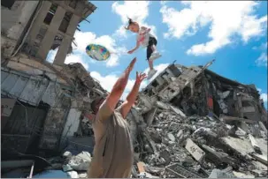  ?? ASHRAF AMRA / VIA GETTY IMAGES ?? In a devastated neighborho­od of Gaza City, joy is expressed by Palestinia­ns on Saturday following a cease-fire that took effect the previous day.