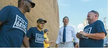  ?? KEVIN RICHARDSON/ BALTIMORE SUN ?? Candidate for Baltimore City state’s attorney Ivan Bates shares a laugh with members of his team outside William Paca Elementary voting location.