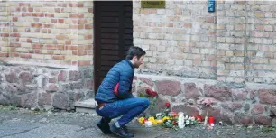  ?? (Fabrizio Bensch/Reuters) ?? A MAN lays flowers outside the synagogue in Halle, Germany, in October, after two people were killed in a shooting.