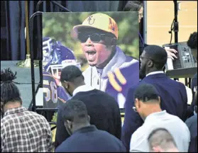  ?? HYOSUB SHIN / HSHIN@AJC.COM ?? Students gather before a photograph of Quentin Moses during a memorial service in February at Reinhardt University. Moses was an assistant football coach there before he died with two others in a house fire.