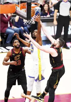  ??  ?? Kevin Durant (centre) of the Golden State Warriors battles with Kevin Love (right) of the Cleveland Cavaliers for a rebound in the first half during Game Three of the 2018 NBA Finals at Quicken Loans Arena in Cleveland, Ohio. — AFP photo