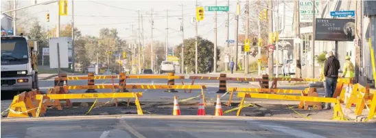  ?? PAT MCGRATH/OTTAWA CITIZEN ?? Crews were paving over Monday’s sinkhole on Boulevard St. Joseph near the Place d’Orléans Mall in Orléans on Tuesday when another water main ruptured nearby on St. Jean Street.