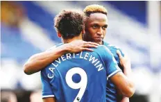  ?? AFP ?? Everton’s striker Dominic Calvert- Lewin and defender Yerry Mina hug each other after their match against Liverpool.