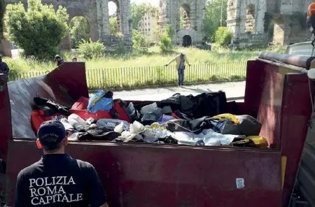  ??  ?? Degrado Un cassone dell’Ama ricolmo di oggetti (indumenti, borsoni, rifiuti) sequestrat­i dai vigili urbani a Porta Maggiore