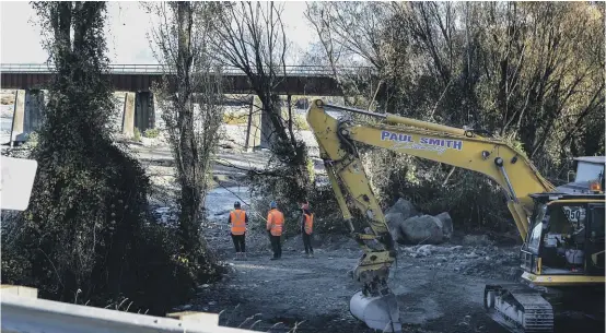  ?? JOHN BISSET/THE TIMARU HERALD ?? Contractor­s pictured near the Rangitata rail bridge on Tuesday.