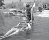  ?? ?? Manuel Giesbrecht is all smiles as he tests out an adaptive water wheelchair at Beauvais Lake with Lucy Gerrand’s assistance.