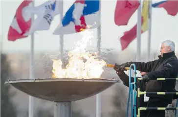  ?? Ted Rhodes/calgary Herald ?? Bob Niven, one of the honorary chairmen of the 55 Plus winter games, fires up the cauldron during the opening on Wednesday at Canada Olympic Park.