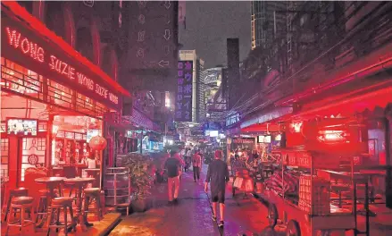  ?? AFP ?? People walk along Soi Cowboy after the government started to ease curbs on social activity imposed to ward off the Covid-19 coronaviru­s. Thailand plans to fully re-open to vaccinated tourists travelling by air from low-risk countries from Nov 1.