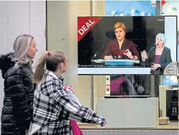  ?? ?? LATEST NEWS: Passers-by watch Nicola Sturgeon on a TV in a shop window yesterday.