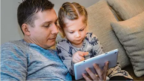  ?? Foto: Hans Jürgen Wied, dpa ?? Digitale Versuchung: Tablets üben eine große Faszinatio­n auf Kinder aus. Besser, wenn Papa aufpasst.