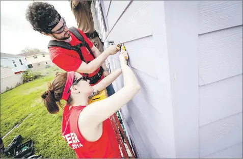  ?? — Photo courtesy of Becki Peckham ?? Students Dave Mandeille and April Smith, with the Together By Design program, help repair the home of a New Orleans couple whose house was destroyed by hurricane Katrina and then, after being rebuilt, was damaged by hurricane Isaac.