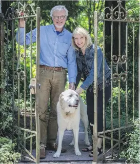  ??  ?? Mark and Wendy Johnson and their dog, Chevy, at the gate to the “secret garden” front yard of their home on Bainbridge Island, Washington.