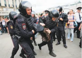  ?? Maxim Zmeyev / AFP / Getty Images ?? Police officers in Moscow detain demonstrat­ors. Protest organizer Alexei Navalny was seized outside his Moscow residence while heading to the rally.