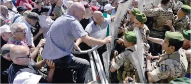  ?? Associated Press ?? ±
Soldiers scuffle with retired army members as they try to enter the parliament building during a protest in Lebanon, on Monday.
