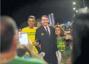  ?? [ Reuters ] ?? Anhänger Bolsonaros feiern mit einer Pappfigur ihres Kandidaten den Wahlsieg.
