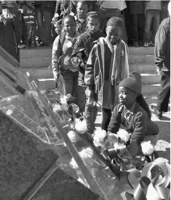  ?? MUJAHID SAFODIEN/AFP/ GETTY IMAGES ?? Children from Soweto bring flowers to the Hector Pieterson Memorial as South Africa celebrated Youth Day on Sunday.