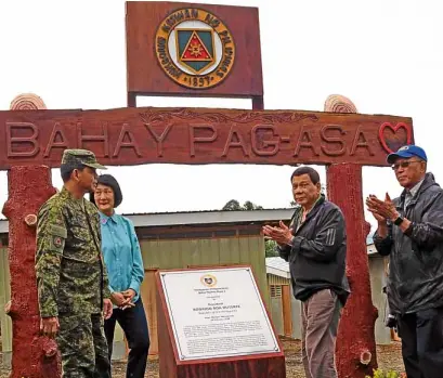  ?? —PHOTO FROM THE PHILIPPINE ARMY ?? BUILDERS President Duterte visits Bahay Pag-asa Phase 2 in Marawi, a housing project for displaced residents of the city, with (from left) Army Maj. Gen. Rolando Bautista, Tarlac Heritage Foundation cofounder Isa Cojuangco Suntay and Defense Secretary...