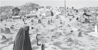  ??  ?? Kabul, Afghanista­n, 2008 — a woman walks through the city’s oldest cemetery.