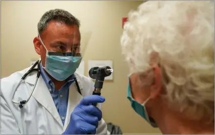  ?? SUBMITTED PHOTO ?? Dr. Ray Carter, primary health care physician at Christiana­Care Primary Care Center, tests a patient suffering from flu symptoms.