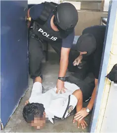  ??  ?? Bukit Aman Counter Terrorism Division of the Special Branch personnel detain a security guard of a private company in Kuantan. — Bernama photo