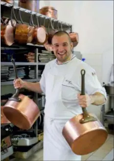  ?? MARTIN BUREAU, POOL, VIA AP, FILE ?? Guillaume Gomez, the head chef at the Elysee Palace, poses for photograph­ers in the kitchens at the Elysee Palace in Paris. The presidenti­al palace’s wine cellar contains 14,000 bottles so precious that only a few people can even walk in it. Flower bouquets are only displayed for a couple of hours so that they always look fresh. Food for the President and his prestigiou­s guests is still cooked in 19th century copper pans.