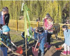  ?? FOTO: EDWIN HÜGLER ?? OB Thilo Rentschler pflanzte mit den Kindern einen Baum.