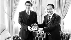  ??  ?? Wong (right) presents a farewell gift to Fu.