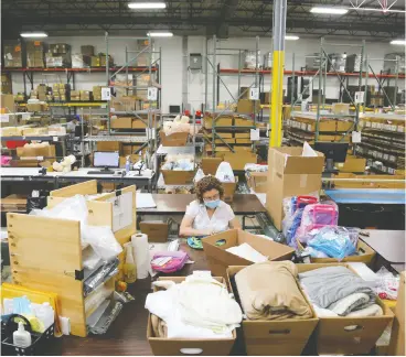  ?? OLIVIA OBINEME / BLOOMBERG ?? An employee wearing a protective mask works in the Woodridge, Ill., warehouse of Gifts For You, which needs 10 more workers to help engrave and ship personaliz­ed gifts.