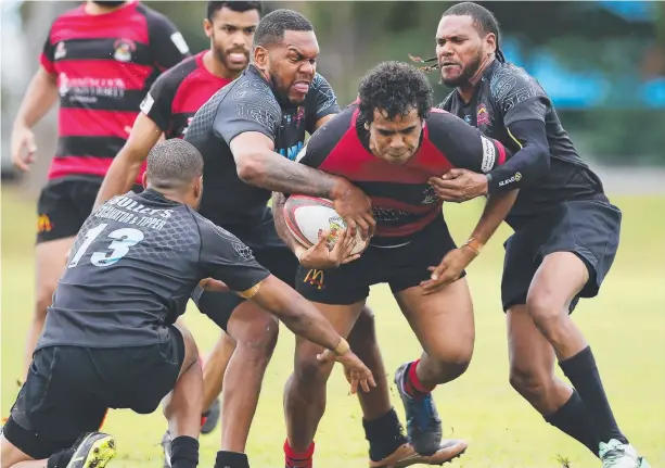  ?? Picture: BRENDAN RADKE ?? STRONG EFFORT: Southside Crusaders defenders attempt to halt a storming run by JCU's Suma Nona. TOM VOLLING