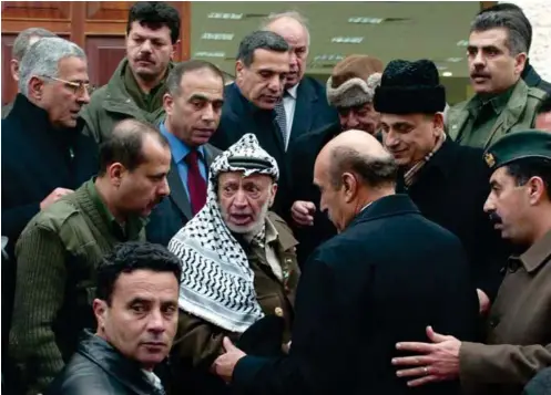  ??  ?? Yasser Arafat à Ramallah, le 27 janvier 2004, après un entretien avec Omar Souleiman (de dos), directeur du Service de renseignem­ent général égyptien de 1993 à janvier 2011.