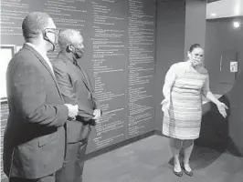  ??  ?? History Center Chief Curator Pam Schwartz explains conflictin­g views of the Ocoee Massacre to the Rev. Stephen Nunn, left, and Orange County Mayor Jerry Demings.