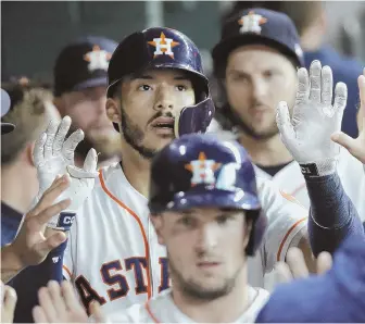  ?? AP PHOTO ?? THE CHAMPS ARE HERE: Carlos Correa is congratula­ted after hitting a two-run home run off Drew Pomeranz during the first inning last night in Houston.