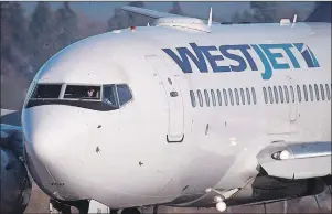  ?? CP PHOTO/DARRYL DYCK ?? A pilot taxis a Westjet Boeing 737-700 plane to a gate after arriving at Vancouver Internatio­nal Airport on February 3, 2014. A recent successful bid to unionize WestJet pilots has prompted a push to organize flight attendants at the airline.