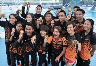  ??  ?? ... Malaysian divers show off their prizes after collecting all 13 gold medals in aquatic diving events of the 29th SEA Games at the National Aquatic Centre in Bukit Jalil yesterday.