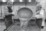  ?? Judy Dehaas, Denver Post file ?? Ramon Aguyo, left, and Keo Bongphacke­y pour melted sugar onto a cooling tray at Hammond's Candies in 2009. Visitors can tour the Denver factory.