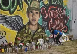  ?? JAY JANNER/AMERICAN-STATESMAN ?? Mellisa Mendoza places white roses at a mural for Spc. Vanessa Guillen. Guillen was a soldier in the U.S. Army who went missing from Fort Hood in April and is believed to have been killed by another soldier.