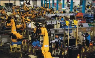  ?? CHINATOPIX VIA ASSOCIATED PRESS ARCHIVES ?? A report entitled “Rogue Automation” says that because factory robots are connected to networks and run via software, a hacker could get into the system to steal data or even control the robot.