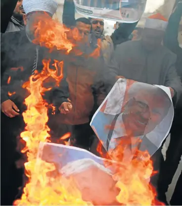  ?? /Reuters ?? Reaction: Palestinia­n protesters burn posters depicting US President Donald Trump and Israeli Prime Minister Benjamin Netanyahu during a protest in Gaza City on Thursday against the decision by Trump to recognise Jerusalem as the capital of Israel.