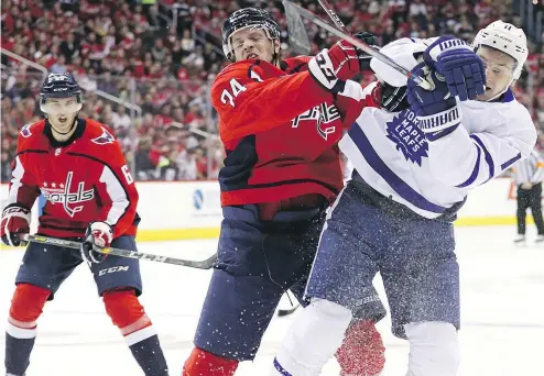  ?? — GETTY IMAGES ?? Washington’s John Carlson runs into Toronto’s Zach Hyman during the first period of the Capitals-Leafs game at Capital One Arena Saturday night in Washington. The Leafs won, 4-2.