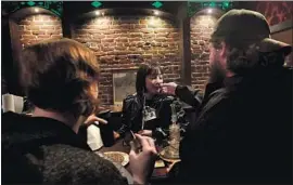  ?? Jeff Chiu Associated Press ?? NIKKI DASIG, center, smells a customer’s marijuana product at Barbary Coast Collective, which closely resembles the pot-selling coffee shops in Amsterdam.