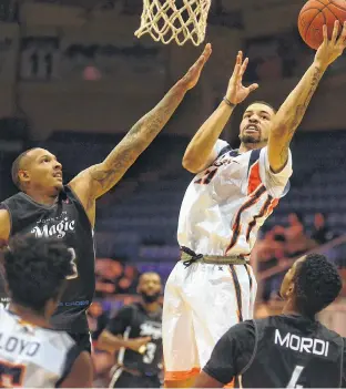  ?? JASON MALLOY/SALTWIRE NETWORK ?? Island Storm guard Antwon Lillard, right, takes a shot as Moncton Magic forward Billy White goes for the block during the first game of the 2019-20 National Basketball League of Canada regular season Thursday at the Eastlink Centre.