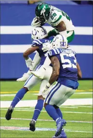  ?? AJ Mast / Associated Press ?? Jets running back Kalen Ballage (29) tries to leap over the Colts’ Jonathan Taylor and Darius Leonard (53) in the second half on Sunday in Indianapol­is.