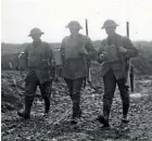  ?? HENRY ARMYTAGE SANDERS ?? Three New Zealand soldiers walking down a muddy road at La Signy Farm April 1918 carry ceramic flagons of rum for issue to troops on the front line.
