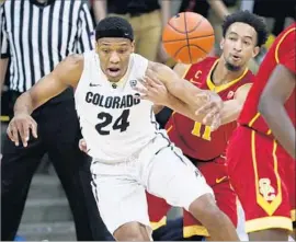  ?? David Zalubowski Associated Pres ?? COLORADO GUARD George King, left, has the ball knocked out of his hands by USC guard Jordan McLaughlin during the first half.