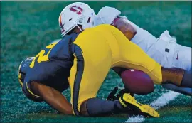  ??  ?? Cal’s Chris Street (24) attempts to recover a fumbled punt return against Stanford in the second quarter. Stanford’s Thomas Booker recovered the fumble on the play.