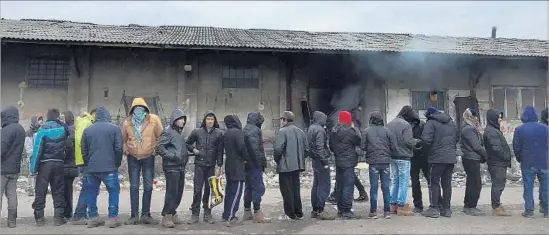  ?? Photograph­s by Shashank Bengali Los Angeles Times ?? PEOPLE wait in line for food in Belgrade, Serbia. Hundreds of Afghans, Pakistanis, Syrians and others camp here in abandoned warehouses in freezing temperatur­es.