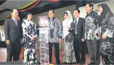  ??  ?? Abang Johari (third left) looking at a tablet as he launches SKDP while (from left) Gerawat, Yasmin, Fatimah, Wong, Harden and Ministry of Welfare, Community Wellbeing, Women, Family and Childhood Developmen­t permanent secretary Dr Saadiah Abdul Samat...