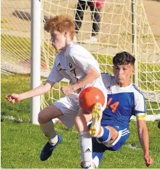  ?? GREG SORBER/JOURNAL ?? Los Lunas’ Jordan Arballo (14) kicks the ball around Valley’s Thomas Bonell during a 4-1 Tigers victory Tuesday. Los Lunas is 7-0 and ranked the top overall boys program in the state.