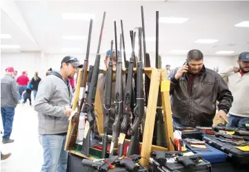  ?? — AFP photo ?? Attendees walk through a Sweetwater Rifle and Pistol Club show at the Nolan County Coliseum in Sweetwater,Texas.