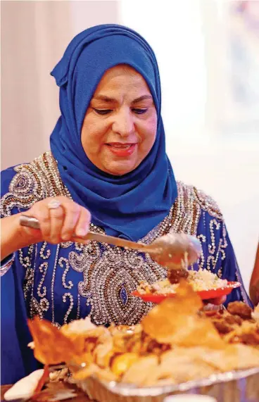  ??  ?? Wafaa Aldoori serves the Iraqi cuisine she prepared for a Refuge Supper Club gathering at Elemental Coffee in downtown Oklahoma City.